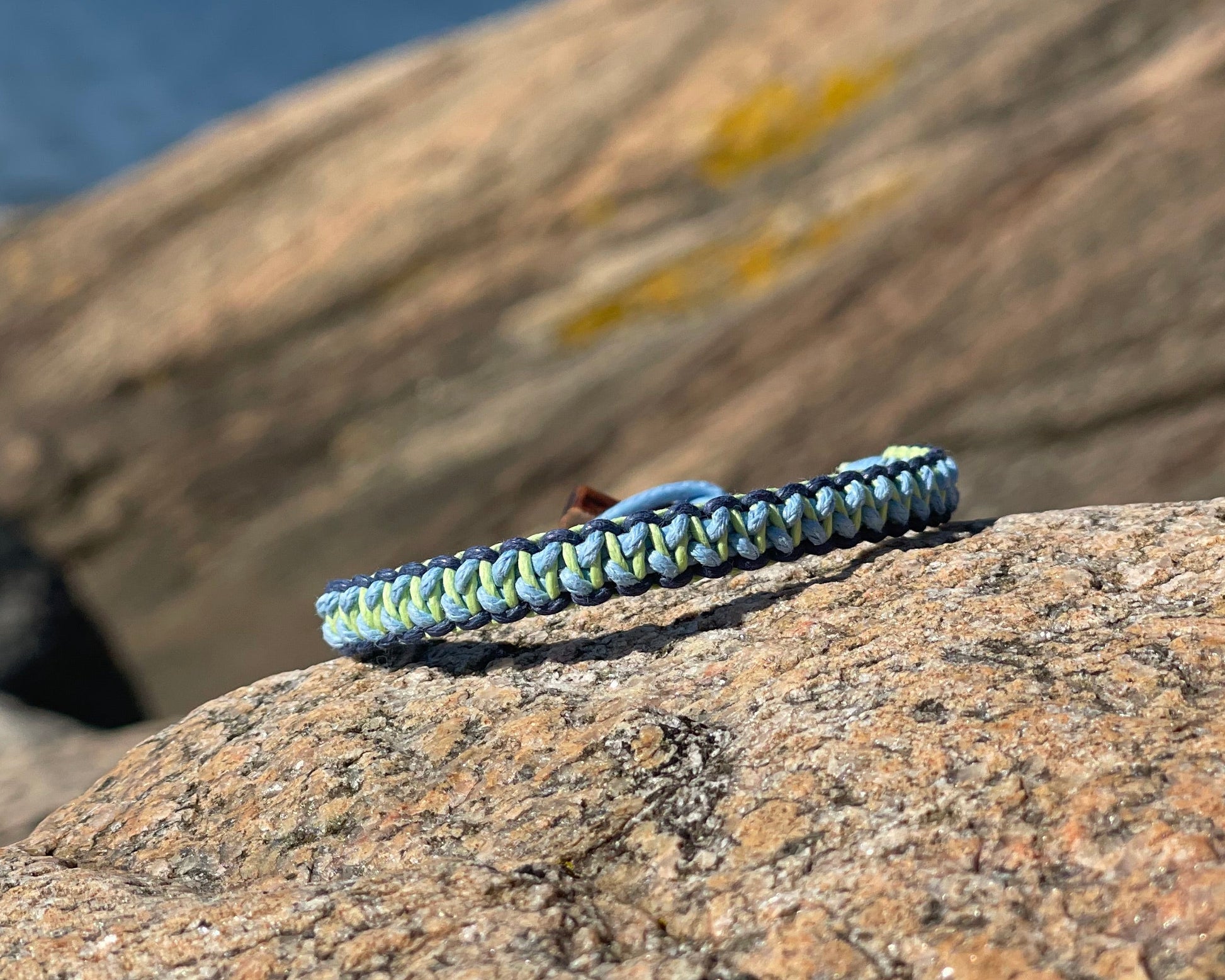 CleanSea bracelet on a rock with blurred natural background. 